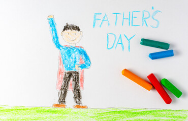 The father in the red superhero cape is depicted in a children's drawing. The inscription father's Day.