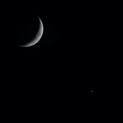 Beautiful closeup view of a crescent moon and a star during the night
