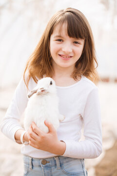Portrait of a girl in white with a white rabbit
