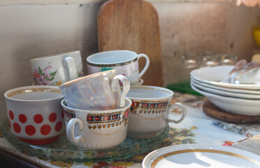 Rural kitchen interior. Cups and plates on the table. Rustic kithenware. Vinage kitchen utensil. Still life with old-fashioned teacups and plates. Culinary in village.
