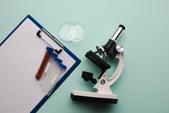 Microscope, test tubes and watch glass on a blue background. Laboratory concept
