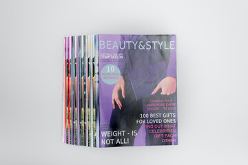 top view of colorful beauty and style magazines isolated on grey.
