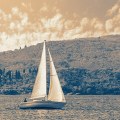 Beautiful Mediterranean landscape with sailing boat on water.  Montenegro, Kotor Bay. Color toned