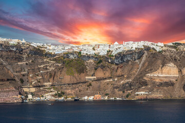 Fira at sunset. Capital of the Greek Aegean Island of Santorini. Panoramic view of Fira from the sea. - obrazy, fototapety, plakaty