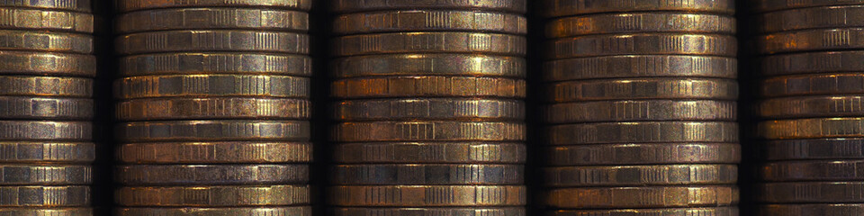 Stacks of coins closeup. Coin texture. Brown business banner or headline made of many coin edges. Economy finance and banking. Macro