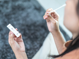 Young woman using rapid antigen test kit for COVID-19 self test at home. Adult woman unpacking a swab for inserts into her nose. COVID-19 pandemic protection concept.Home test, Home Isolation concept