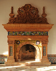 Large Sevillian regionalist style fireplace with bricks and tiles inside an old Sevillian house. Seville regionalism architecture, Spain - obrazy, fototapety, plakaty