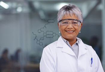 Her discovery will change lives. A female scientist standing before a glass board with a formula on...