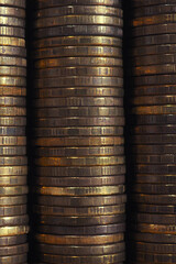 Stacks of coins closeup. Coin texture. Brown business vertical background. Wallpaper made of many coin edges. Economy finance and banking. Macro