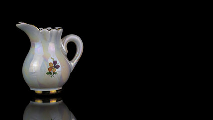 Closeup shot of a porcelain jug isolated on black background - Powered by Adobe