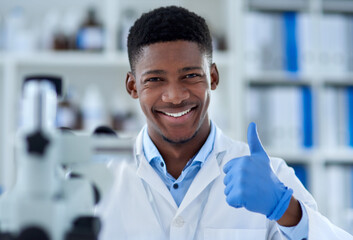 A job well done. Portrait of a cheerful young male scientist wearing protective gloves while...