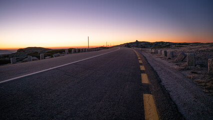 Nahaufnahme einer Straße mit Sonnenuntergang im Hintergrund