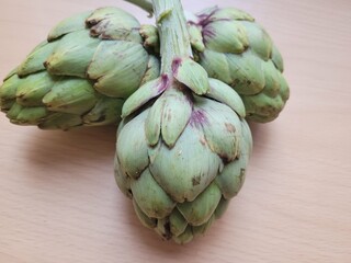 Obraz premium artichokes on a wooden background. Fresh vegetables