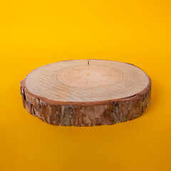 wooden stump or natural style wooden coaster isolated on orange background