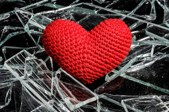 red knitted heart on shards of glass
