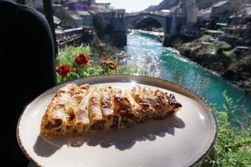 Fotobehang Stari Most Bosnian and Balkans food, Burek Pie with Old Bridge view,Mostar, Bosnia and Herzegovina