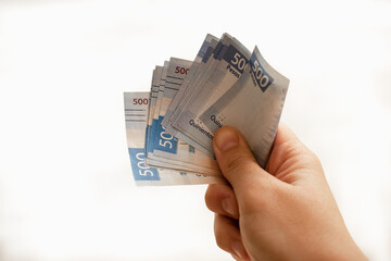 Mano sosteniendo fajo de billetes de quinientos pesos mexicanos.