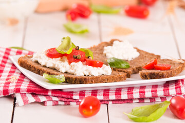 Rye bread with cottage cheese, basil and tomato.