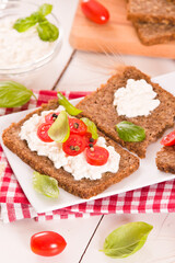 Rye bread with cottage cheese, basil and tomato.