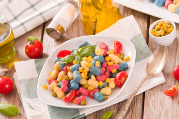 Colored gnocchi with vegetables and sweet corn.