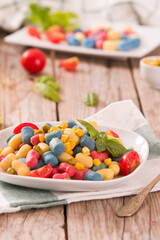 Colored gnocchi with vegetables and sweet corn.