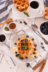 Waffles with blueberries and whipped cream.