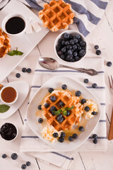 Waffles with blueberries and whipped cream.