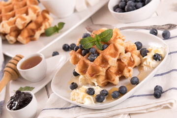 Waffles with blueberries and whipped cream.