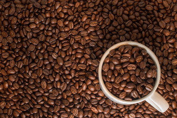 Many coffee beans in a traditional cup and at background 