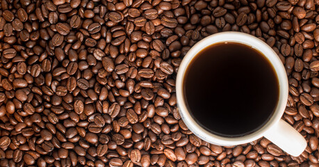 Black traditionl coffee cup on many coffee beans at background 