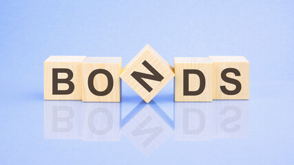 text Bonds - letters by on woodens blocks on pale lilac background, in concept of business and corporation