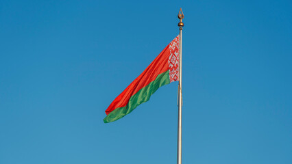 State flags of the Republic of Belarus are waving in the wind on blue sky background. Space for text.