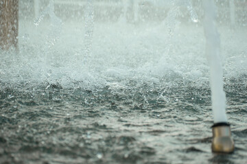 stream of water and splashes in a city fountain. water drops in a fountain. fountain