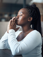 I pray that things get better. Cropped shot of an attractive young woman kneeling alone and praying...