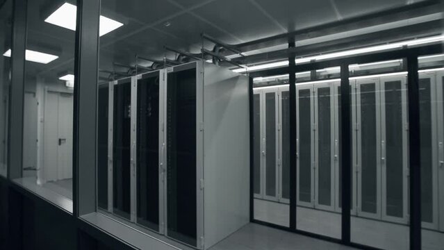 Shot of Corridor in Working Data Center Full of Rack Servers and Supercomputers with High Internet Visualisation Projection. IT sector, technologies concept