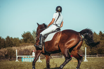 A woman jockey participates in competitions in equestrian sport, jumping.