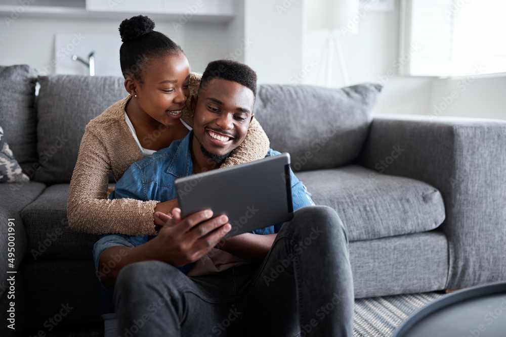 Poster sharing in a very special connection. shot of a young couple using a digital tablet together while r