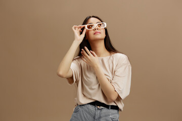 Fototapeta premium Brunette in a beige T-shirt with glasses posing clothing fashion Green background