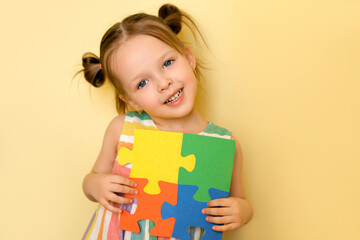 Cute pretty girl shows the pieces of puzzles put together, symbolizing unity and support for people...