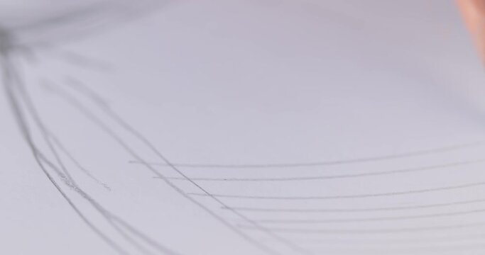 close-up of a pencil that draws synchronous lines on white paper then the designer's hand draws the model of the dress. the artist draws a sketch. close-up