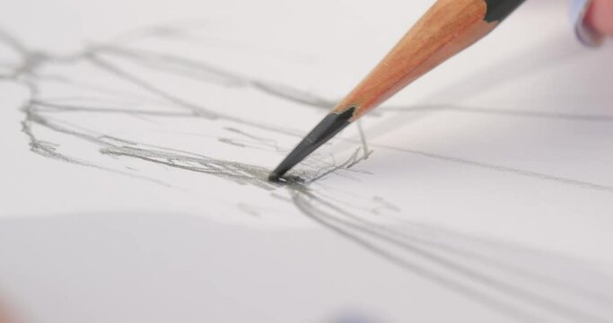 close-up of a pencil that draws the contours of the wedding dress design drawing. girl draws a sketch. close-up
