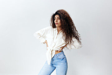 Sexy Curly Pretty Pensive Latin Female Lady in White Shirt tied in bow Holding Hands On Waist copy space, free place Looking Aside Isolated At White Studio Wall Background. Good Offer, Banner, Mockup