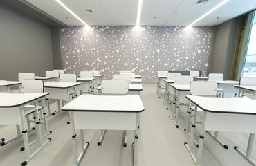 Fototapeta na wymiar New school room with desks and chairs in white color