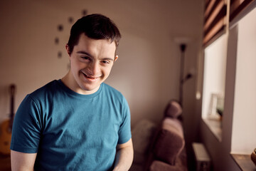 Portrait of happy man with down syndrome at home looking at camera.