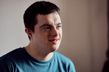 Portrait of smiling man with down syndrome at home.