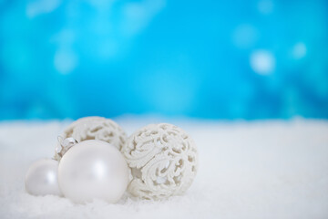 Wishing you a beautiful Christmas. Some christmas baubles lying on a bed of snow.