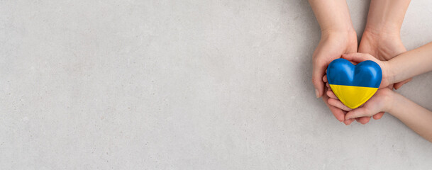 The adult and the child holding Ukraine heart.