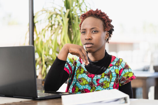 Closeup of young African career woman seeking inspiration while working on her notebook. Girl emancipation and rights concept.