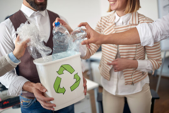 Collecting the trash in the recycling bin at work in the office. Employees, job, office
