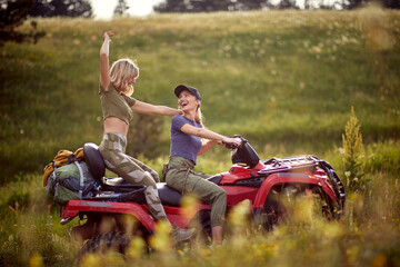 Two young sexy girls enjoy riding the quad in the nature. Riding, friendship, nature, activity © luckybusiness